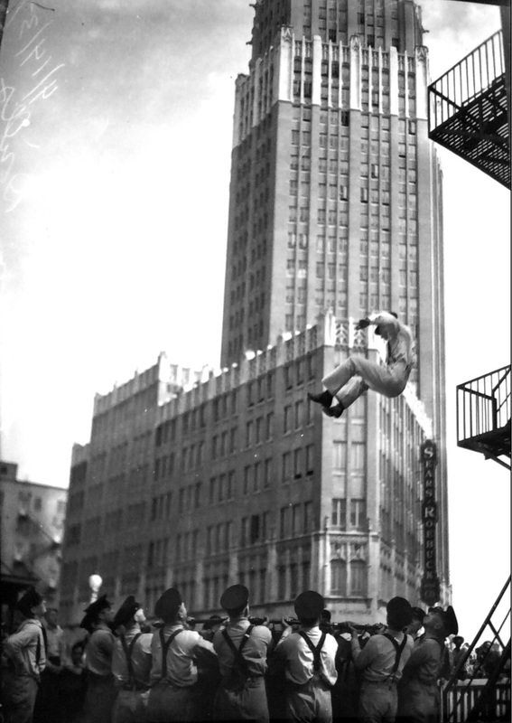San Antonio firefighters practicing catching high rise rescues at the old central firehouse with Smith Young Building in the background.  Note Sears & Roebuck sign. | Drink up the history with The Barwalk, San Antonio TX